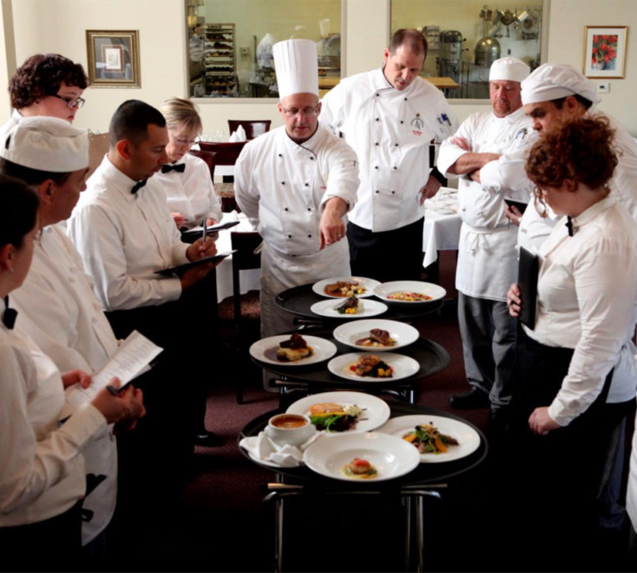 Chefs reviewing plated dishes